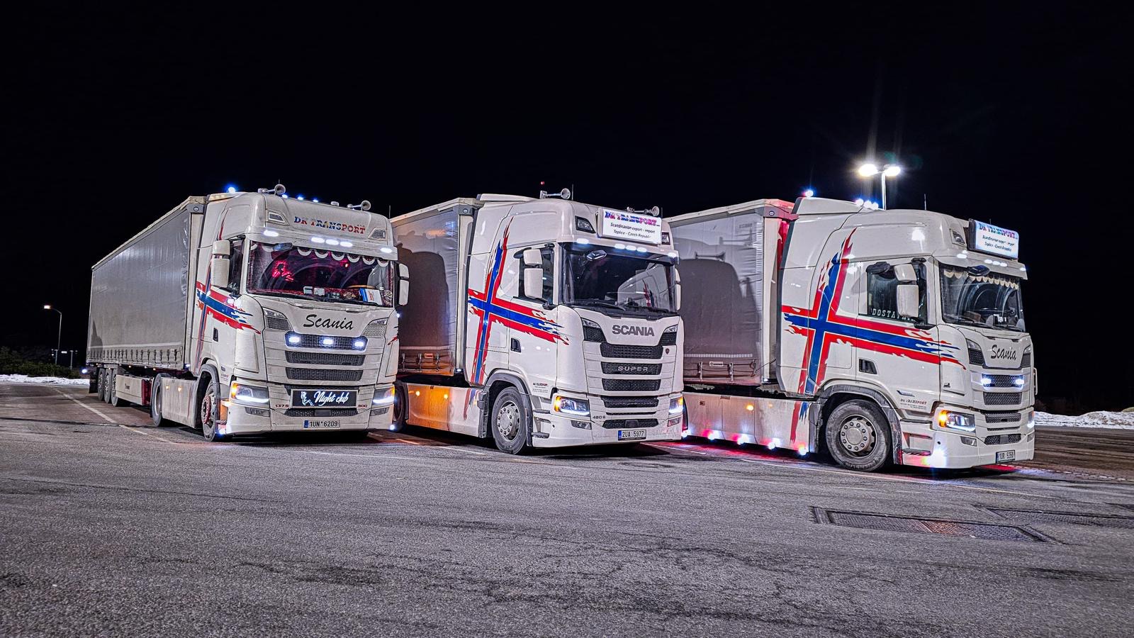 Tři Scanie DK Transport zaparkované v noci