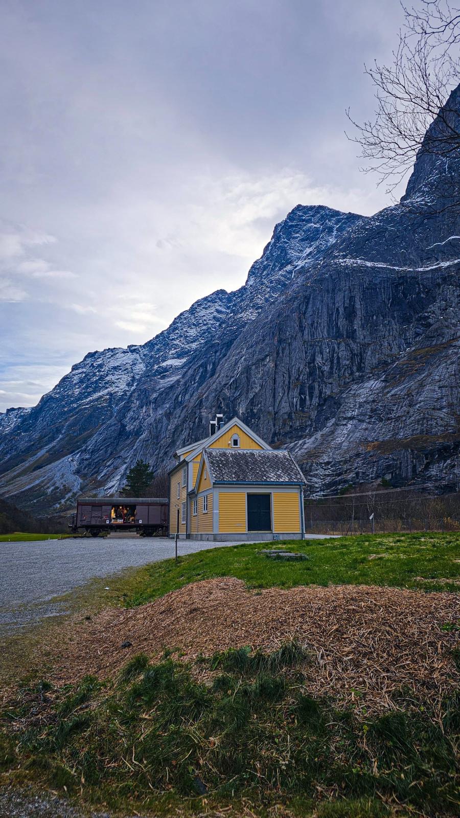 Žlutý norský dům pod monumentální stěnou Trollveggen