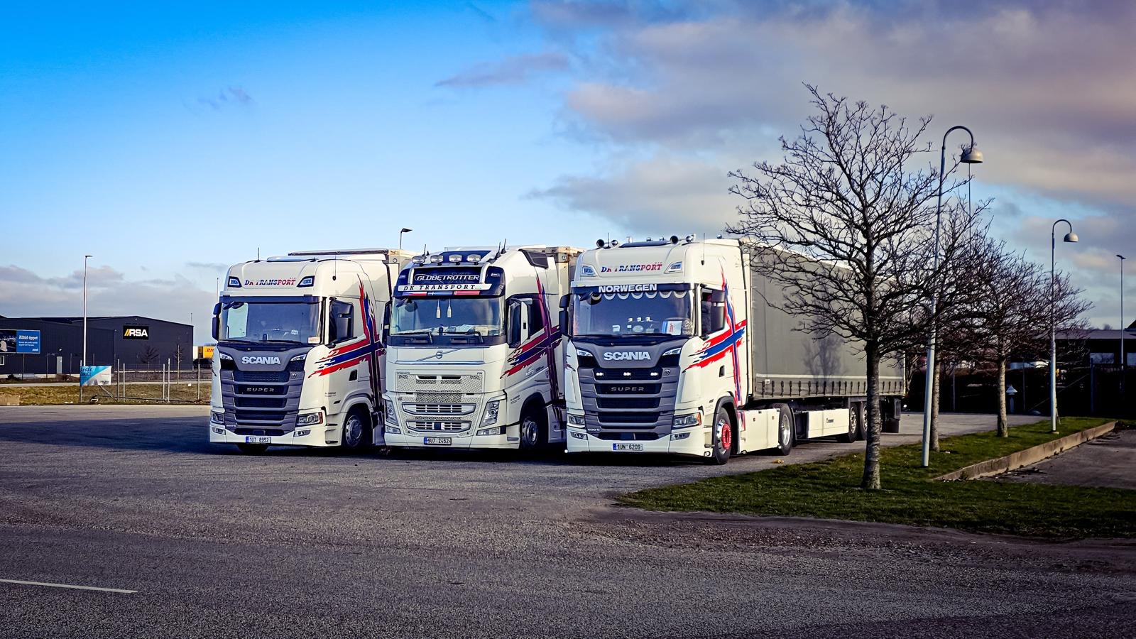 Tři vozy DK Transport – Scania a Volvo – zaparkované vedle sebe
