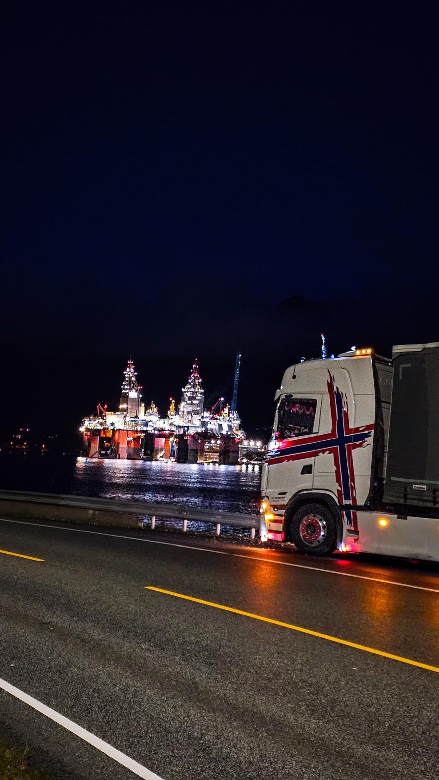 Scania DK Transport s norskou vlajkou u osvětlené ropné plošiny v noci
