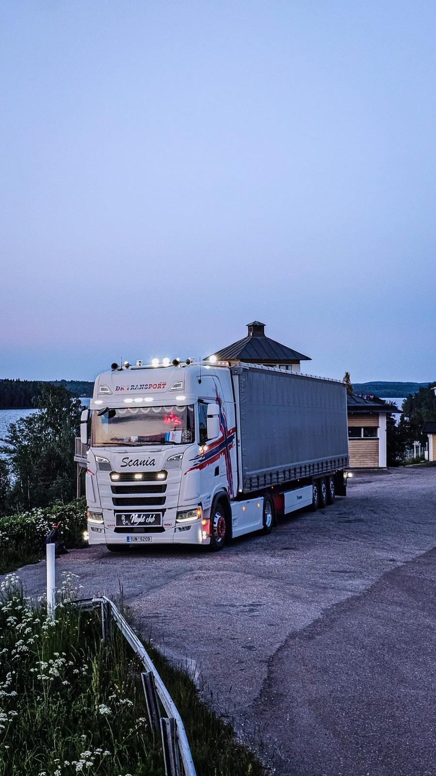 Scania DK Transport u skandinávského jezera za soumraku